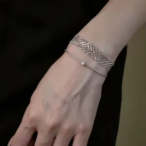 Close-up of minimalist silver metal mesh wrap bracelet and thin adjustable chain