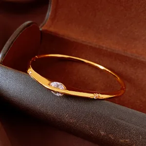 Exquisite close-up of a vintage gold-colored bangle featuring a large oval zircon stone