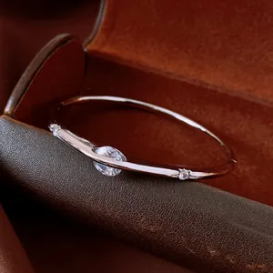 Close-up of retro style silver-toned bangle with round-cut zircon on leather jewelry box
