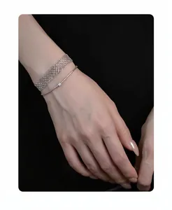 Close-up of minimalist silver metal mesh bracelet and thin stone cord on wrist