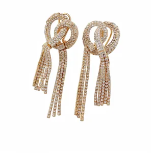 Elegant gold-tone knotted tassel earrings fully encrusted with sparkling clear rhinestones