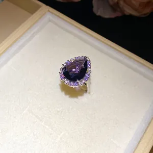 Macro detail shot of a sophisticated pear-cut purple zircon ring with halo stones