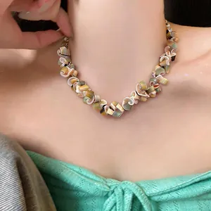 Close-up detail of a vintage irregular shell necklace worn on a model's neck for fashion