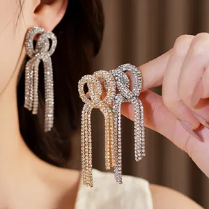 Close-up of sparkling rhinestone knotted tassel earrings with fringe detail