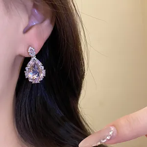 Elegant pear-shaped drop earrings with pink zircon stone and sparkling halo detail on ear