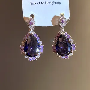 Detailed view of elegant teardrop earrings with purple zircons and pink accents