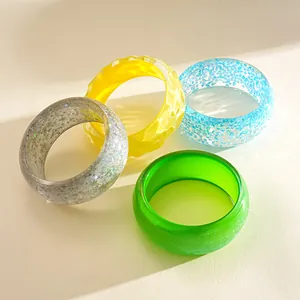 Close-up of four colorful dopamine-style resin chunky bracelets with glitter and texture