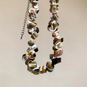 Detailed macro shot of a vintage ethnic style necklace with irregular spiral shell pieces.