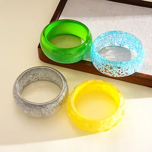 Detailed view of colorful dopamine style resin bangles with varied textures.