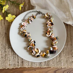 Close-up view of a vintage irregular shell necklace featuring gradient spiral-shaped pieces.