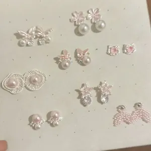 Macro shot showcasing a collection of sweet pink enamel butterfly and pearl stud earrings