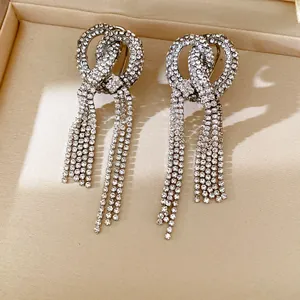 Close-up of sparkling rhinestone knot earrings with long elegant tassel drops
