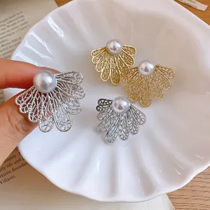 Primer plano de pendientes de perlas con diseño de hoja hueca en colores oro y plata