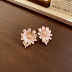 Close-up macro view of elegant pink enamel flower stud earrings with small crystal accent