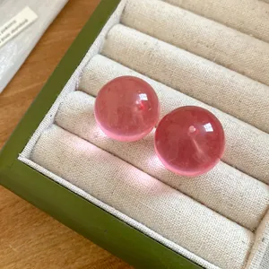 Close-up detail of sweet pink translucent spherical stud earrings in a jewelry box.