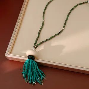 Close-up detail of an ethnic vintage beaded sweater necklace with a turquoise tassel