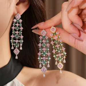 Close-up view of elegant floral tassel earrings with pink and green stones decoration