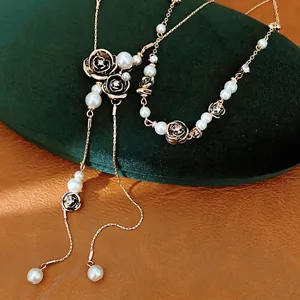 Luxurious gold-tone pearl necklace featuring black rhinestone flowers and tassels
