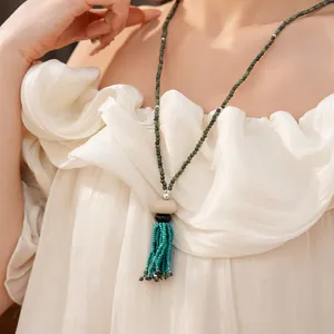 Vintage beaded tassel necklace worn on model with elegant cream ruffled dress