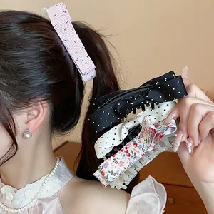 Detail of sweet polka dot and floral cloth bow hair clips shown on model's hair