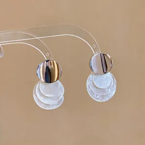 Eleganti orecchini pendenti in metallo spazzolato e tre strati di dischi di conchiglia