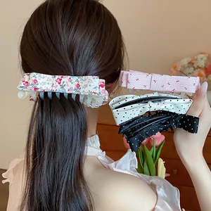 Detailed view of assorted fabric bow hair clips with polka dots and floral prints