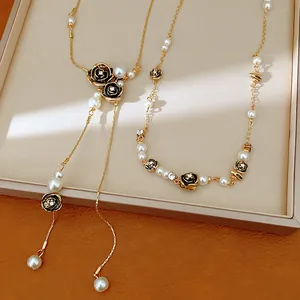 Detailed view of elegant gold chain necklace set with white pearls and black rose charms
