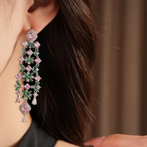 Detailed view of 18k gold plated floral tassel earrings with pink and green zircon stones.