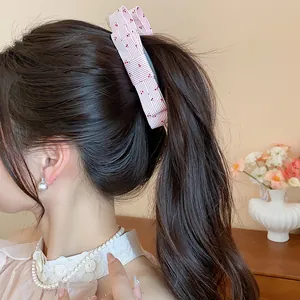 Detailed view of a sweet fabric ribbon bow banana clip worn in a stylish ponytail.