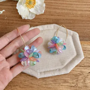 Dettaglio orecchini a sfera con fiori colorati e ganci dorati in stile dopamina