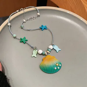 Detail view of summer resort necklace with ceramic shell pendant and starfish charms