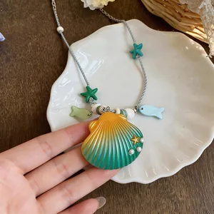 Detailed macro view of ceramic shell pendant necklace featuring starfish and fish charms