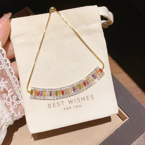 Detail showing multi-color marquise zircon bracelet with an adjustable gold chain on a gift bag