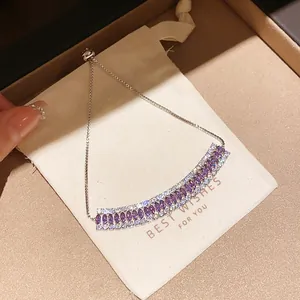 Close-up detail of a dainty purple zircon flower bracelet displayed on a white gift pouch