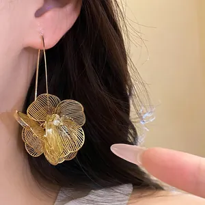 Elegante vergoldete Metall-Hohlblumen-Ohrhänger mit filigranem Drahtdesign