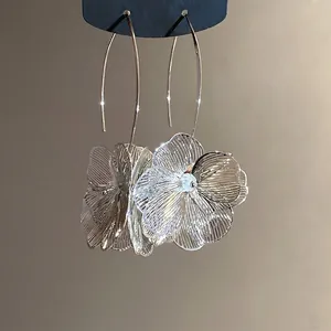 Elegante minimalistische Ohrhaken mit durchbrochenem Metallblumen-Anhänger in Silber-Optik