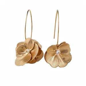 Elegante goldene Blumenohrringe mit strukturierten Blütenblättern und Steinbesatz auf Weiß