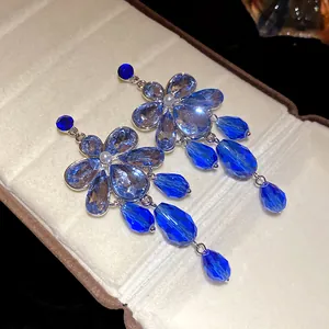 Detailed macro view of elegant blue crystal flower earrings with teardrop pendants