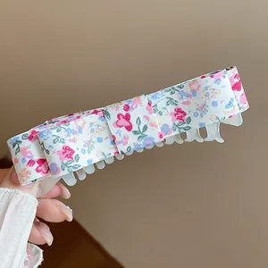 Close-up of elegant floral fabric bow hair clip with sweet pink and blue patterns