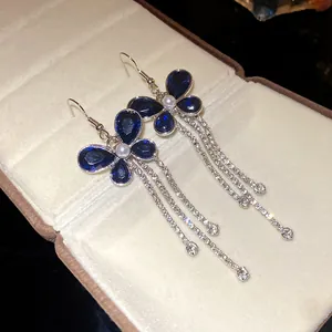 Detailed view of elegant blue crystal butterfly earrings with long rhinestone tassels