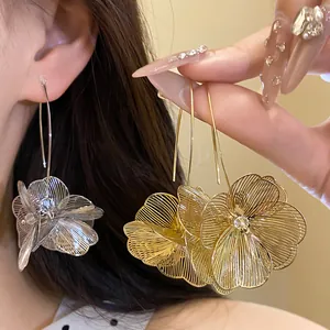 Elegante Ohrringe mit hohlem Metallblumen-Anhänger in Gold und Silber Detailansicht