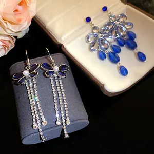 Detail view of elegant blue rhinestone tassel earrings and teardrop earrings in jewelry box