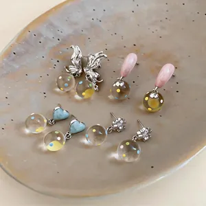 Detailed selection of silver needle earrings featuring butterfly, heart and glass charms