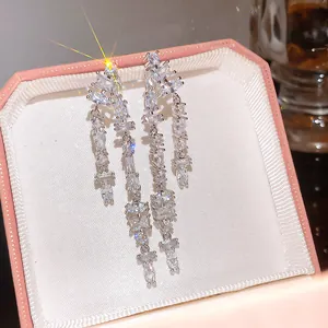 Detailed macro view of super shiny cubic zirconia double-row tassel drop earrings in a gift box