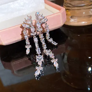 Close-up of silver-tone tassel earrings with sparkling double-row zirconia stones