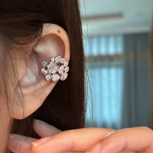 Close-up shot of elegant silver-tone zircon circular beaded ear cuff earring on female ear