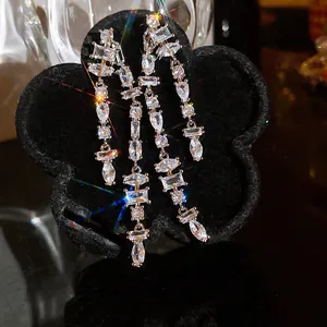 Close-up of elegant double-row sparkling cubic zirconia tassel earrings on black stand