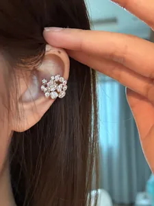 Detailed close-up showing a sparkling zircon cluster ear cuff worn on the ear bone