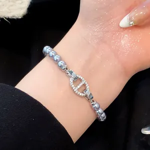 Nahaufnahme eines eleganten lila Perlenarmbands mit zirkonia-besetzter Schnalle am Handgelenk