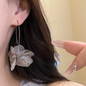 Detailansicht silberner hohler Blumen-Ohrhänger aus Metall mit elegantem Ohrhaken